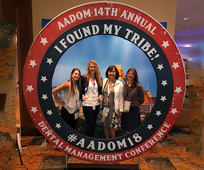 Big circular sign with four female members stood in the middle and smiling